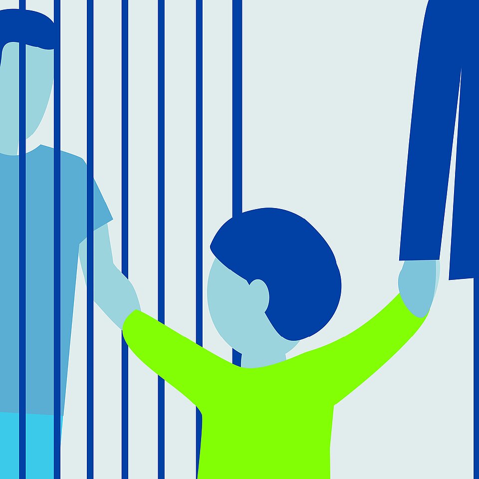 Ein Kind hält die Hand einer erwachsenen Person durch Gitterstäbe.