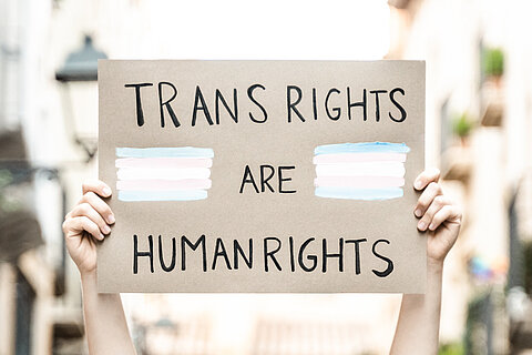 Hochgehaltenes Protestschild mit der Aufschrift "Trans Rights are Human Rights". 